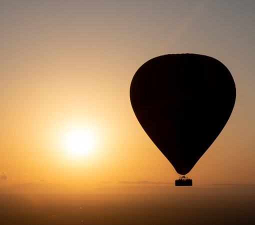 Hot air balloon floating above the Serengeti during a 4-Day Tarangire, Serengeti & Ngorongoro Safari.